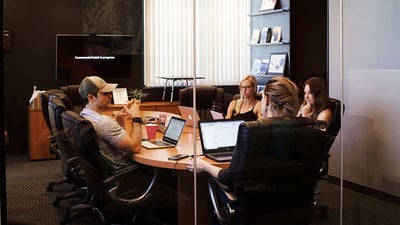 people with computers sitting around a table